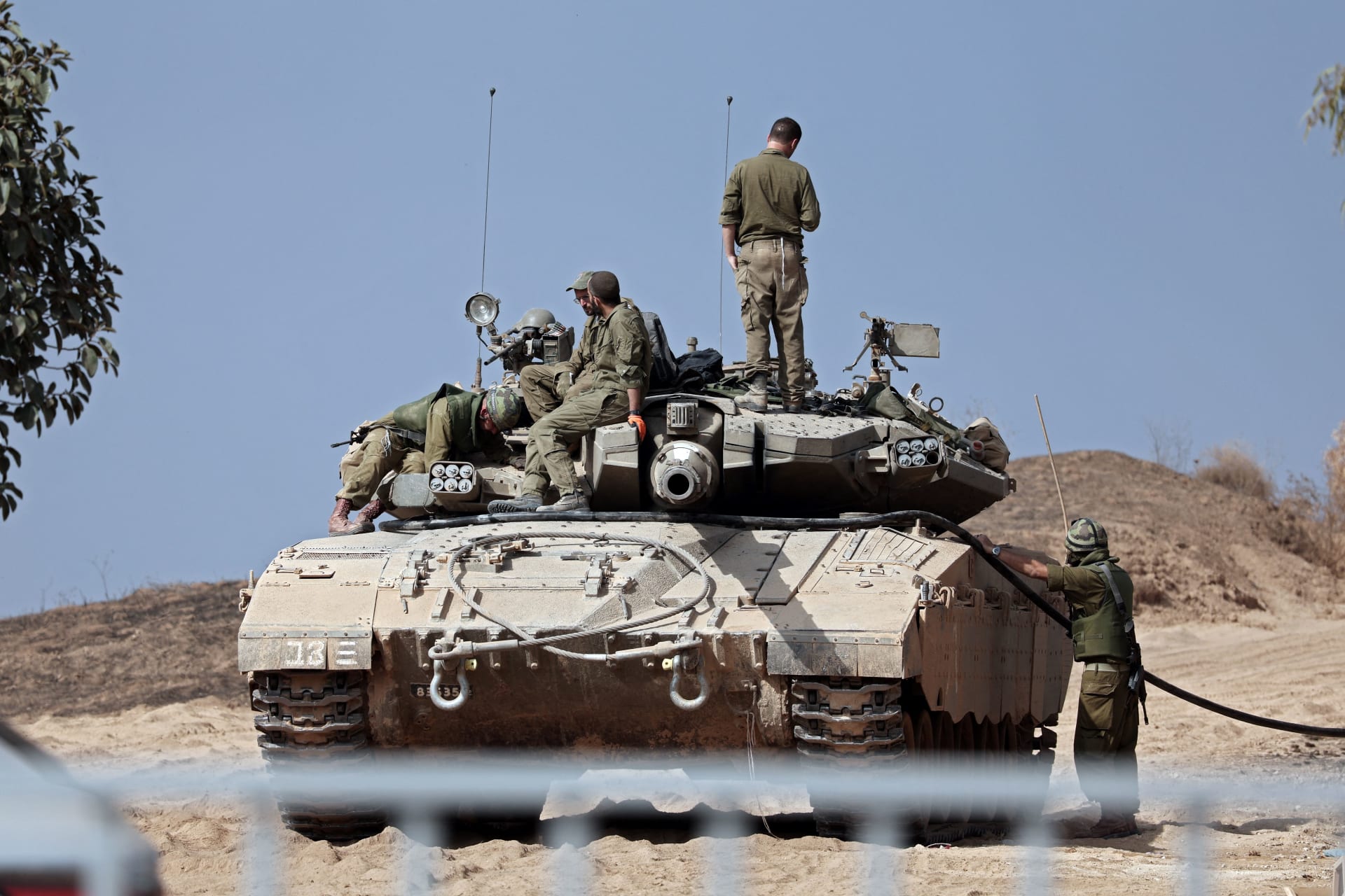 جنود إسرائيليون يزودون دبابتهم ميركافا بالوقود بالقرب من مدينة سديروت بجنوب إسرائيل في 23 أكتوبر، 2023.