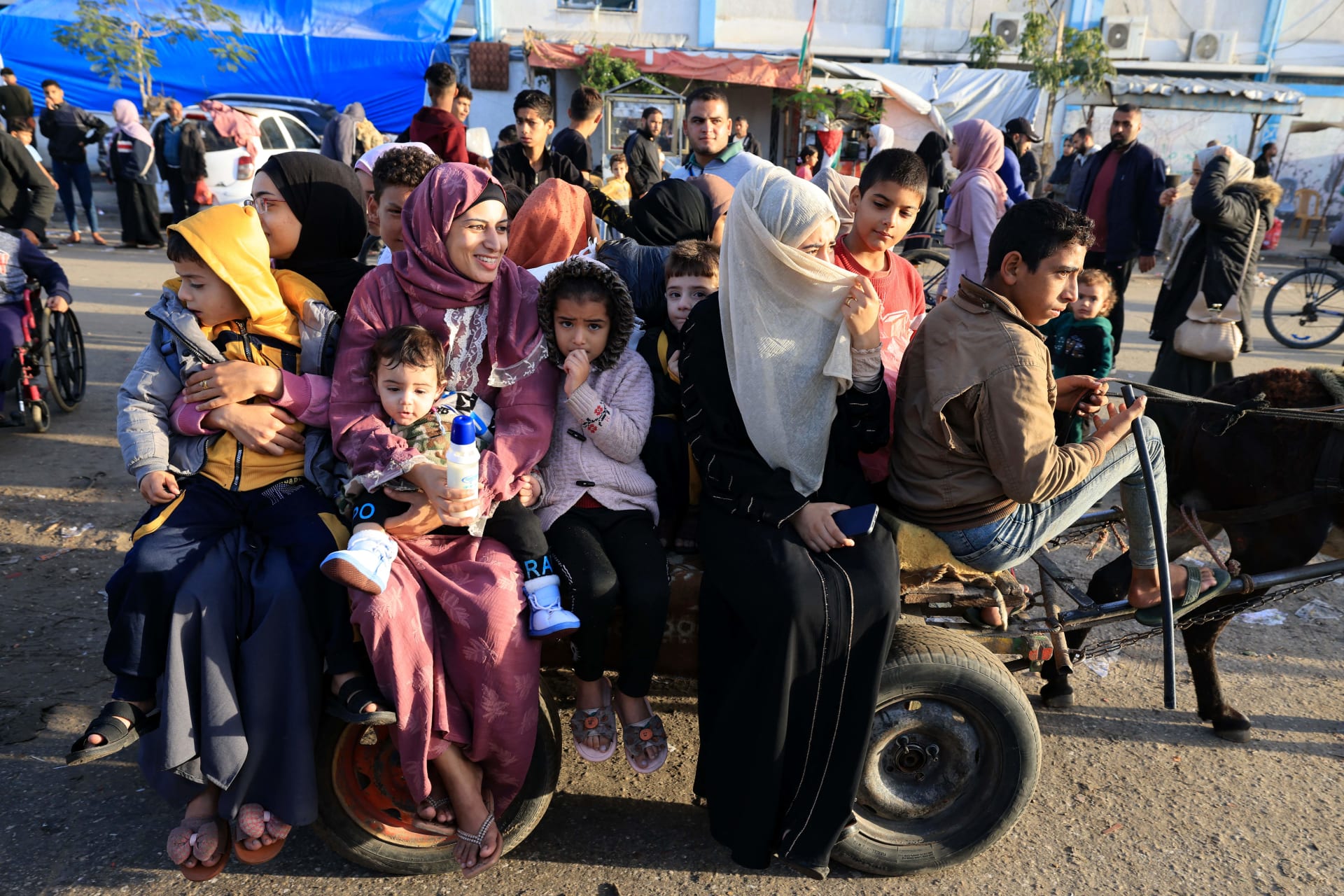 فلسطينيون ممن لجأوا إلى مراكز إيواء مؤقتة يعودون إلى منازلهم شرق خان يونس جنوب قطاع غزة خلال الساعات الأولى من الهدنة، الجمعة.