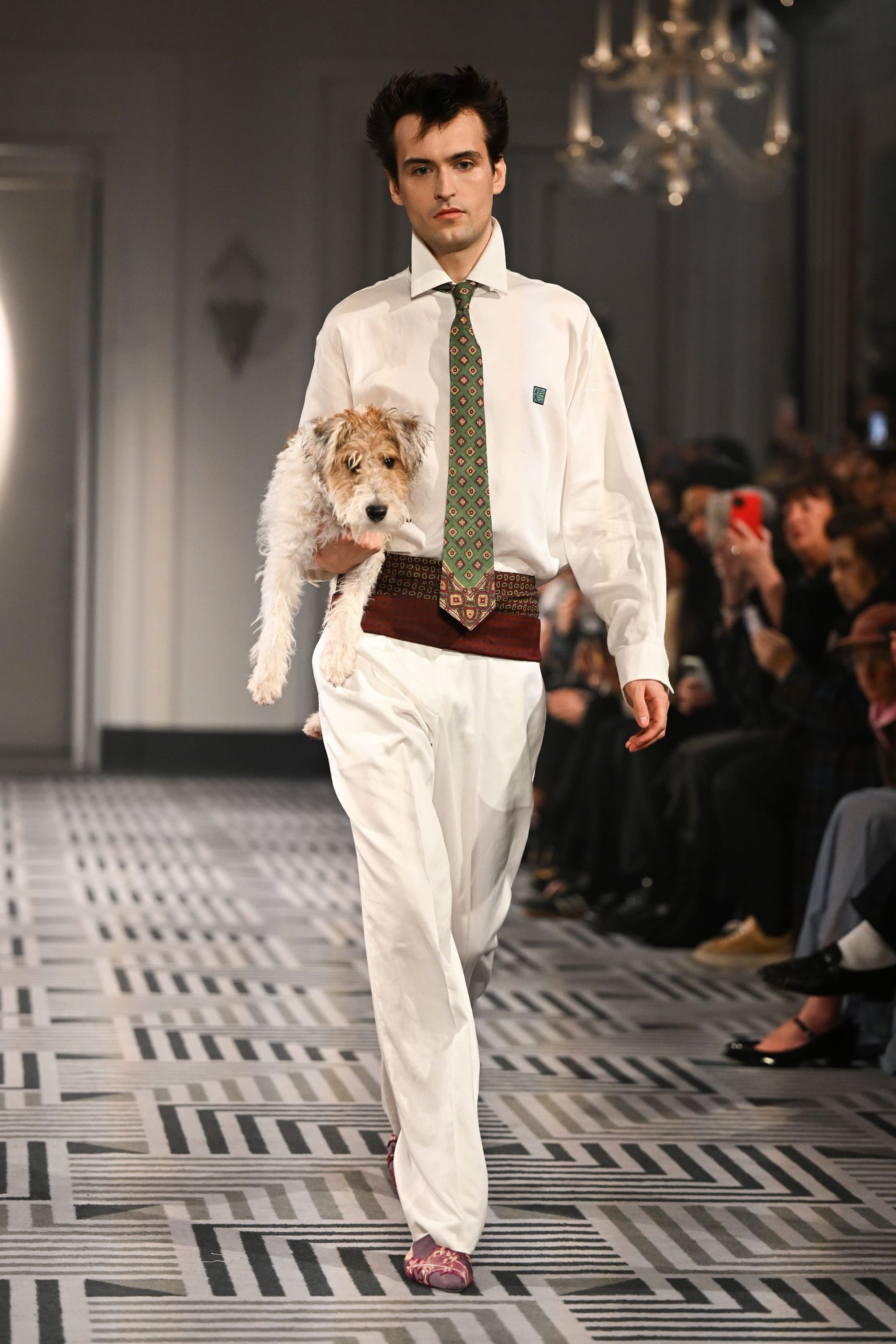 صديق كونر إيفز سار على المنصة حاملاً جرو المصمم الذي يحمل اسم "ريكس".