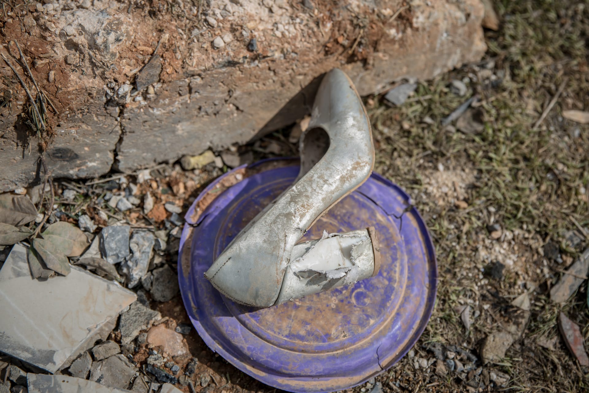 حذاء أبيض بكعبٍ عالٍ تحوّل لونه إلى رمادي. 