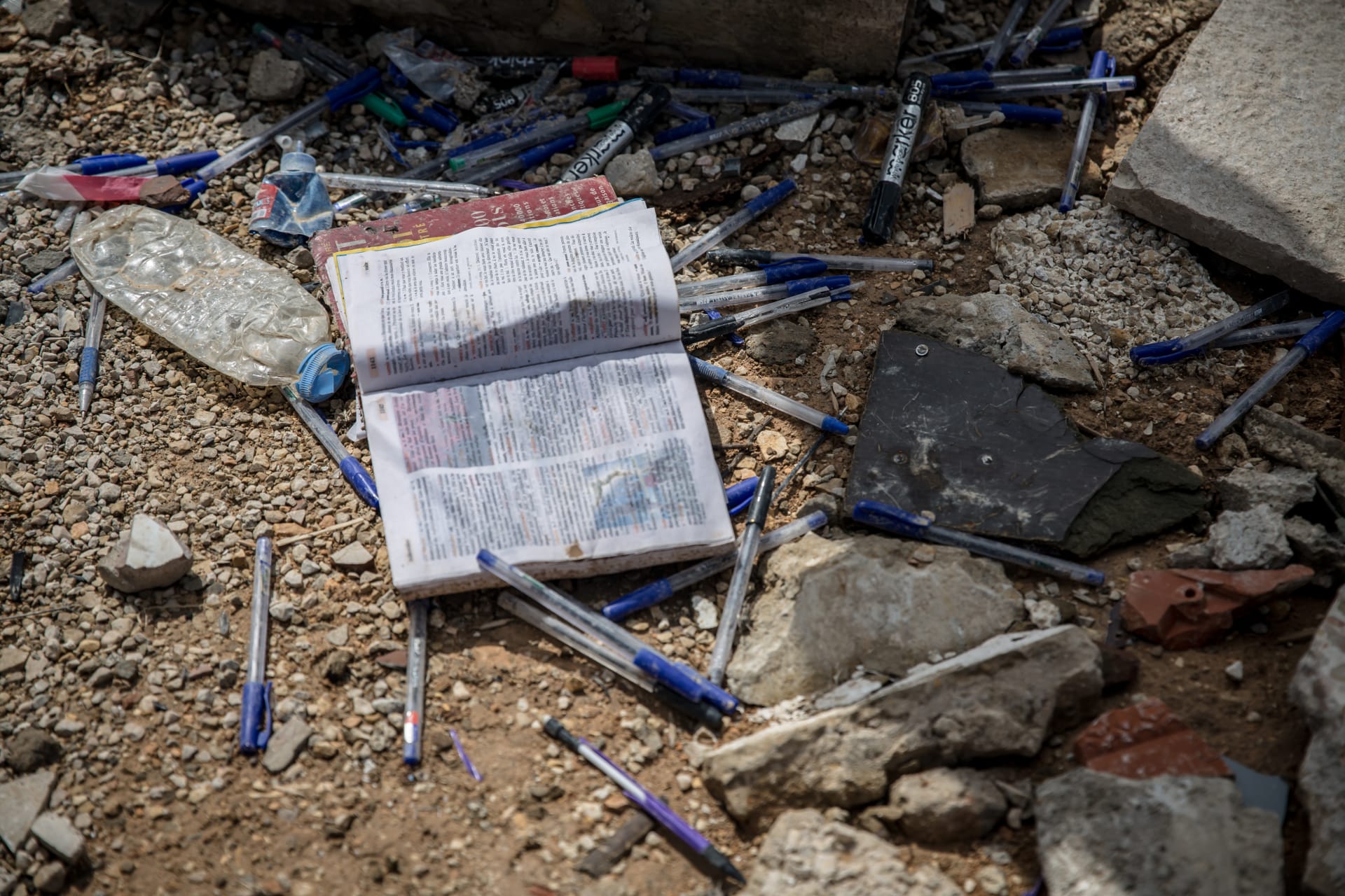 دفاتر وأقلام مدرسيّة وسط الركام. 
