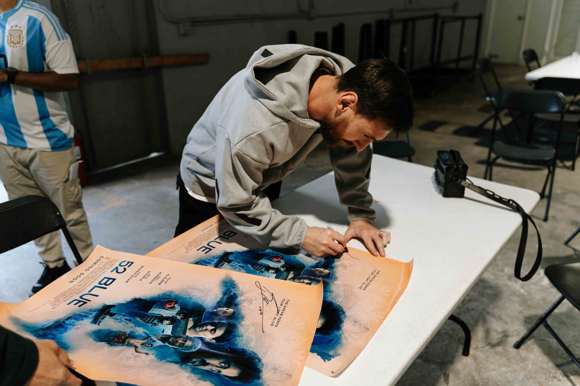 Messi signs poster for the movie "Blue52"