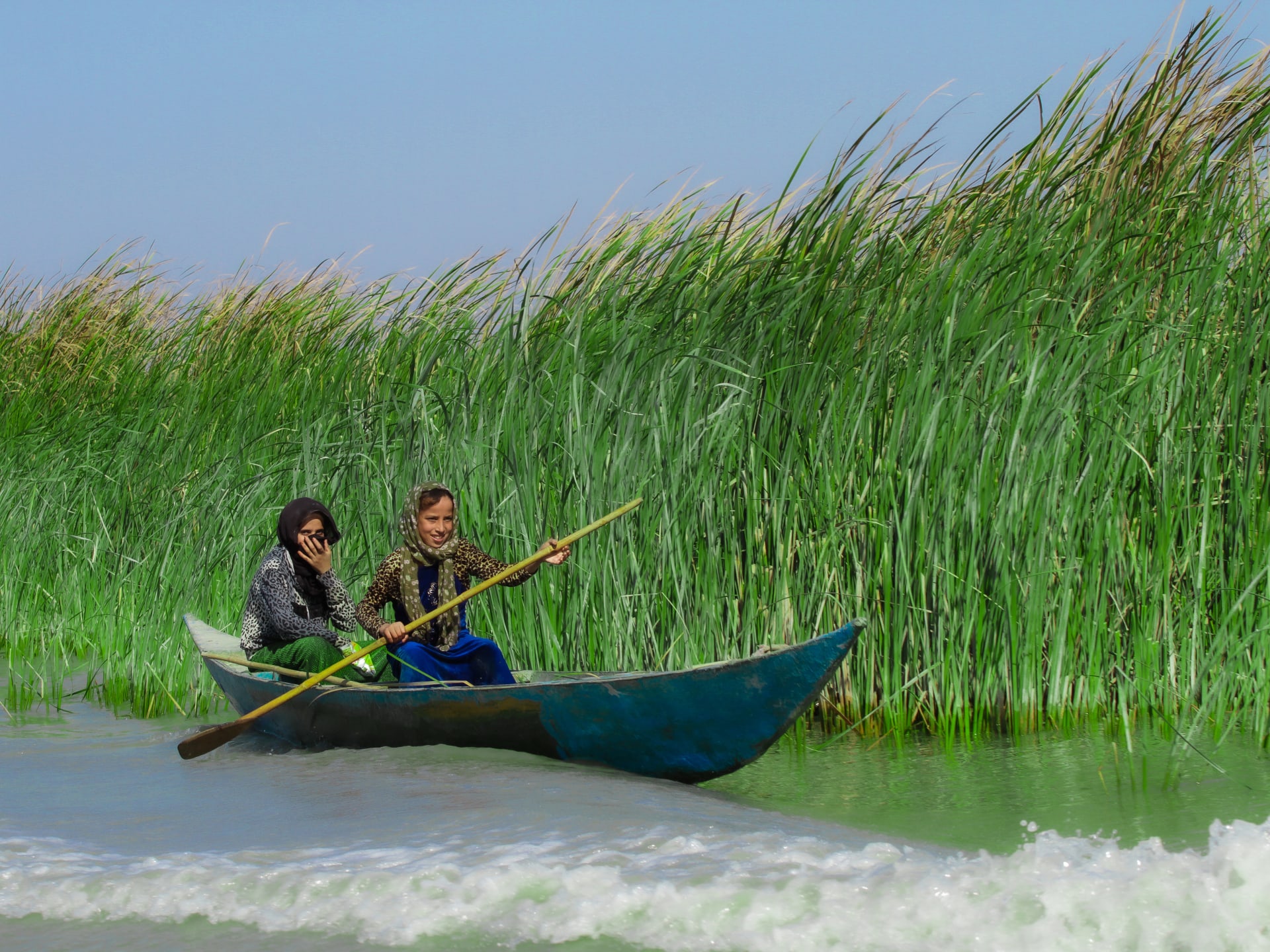 بحقيبتها المدرسية فوق مياه أهوار العراق.. مصور يرصد رحلة طفلة لمدرستها