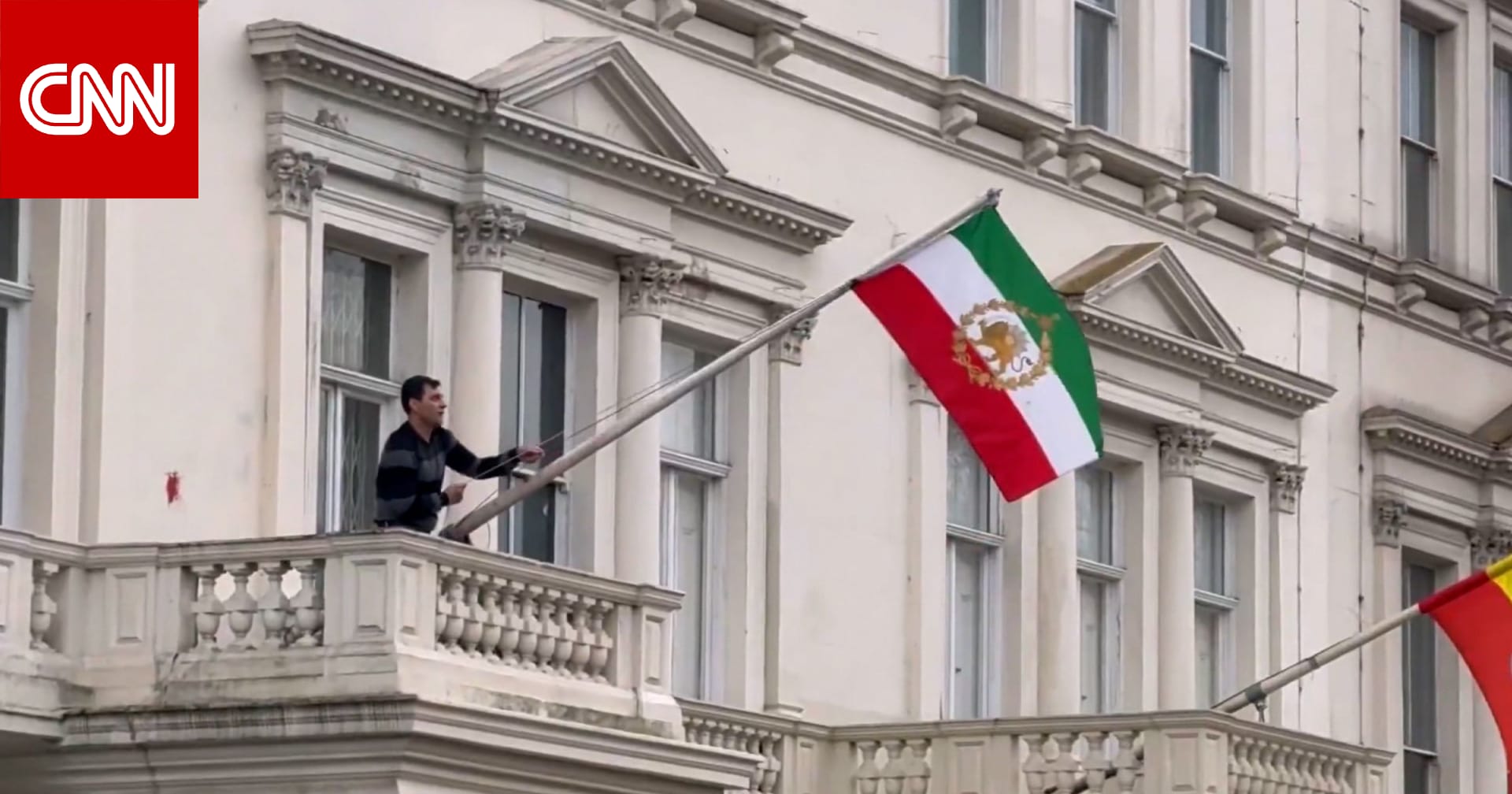شاهد.. محتج ينزع العلم الإيراني ويرفع علم ما قبل الثورة بمبنى السفارة بلندن