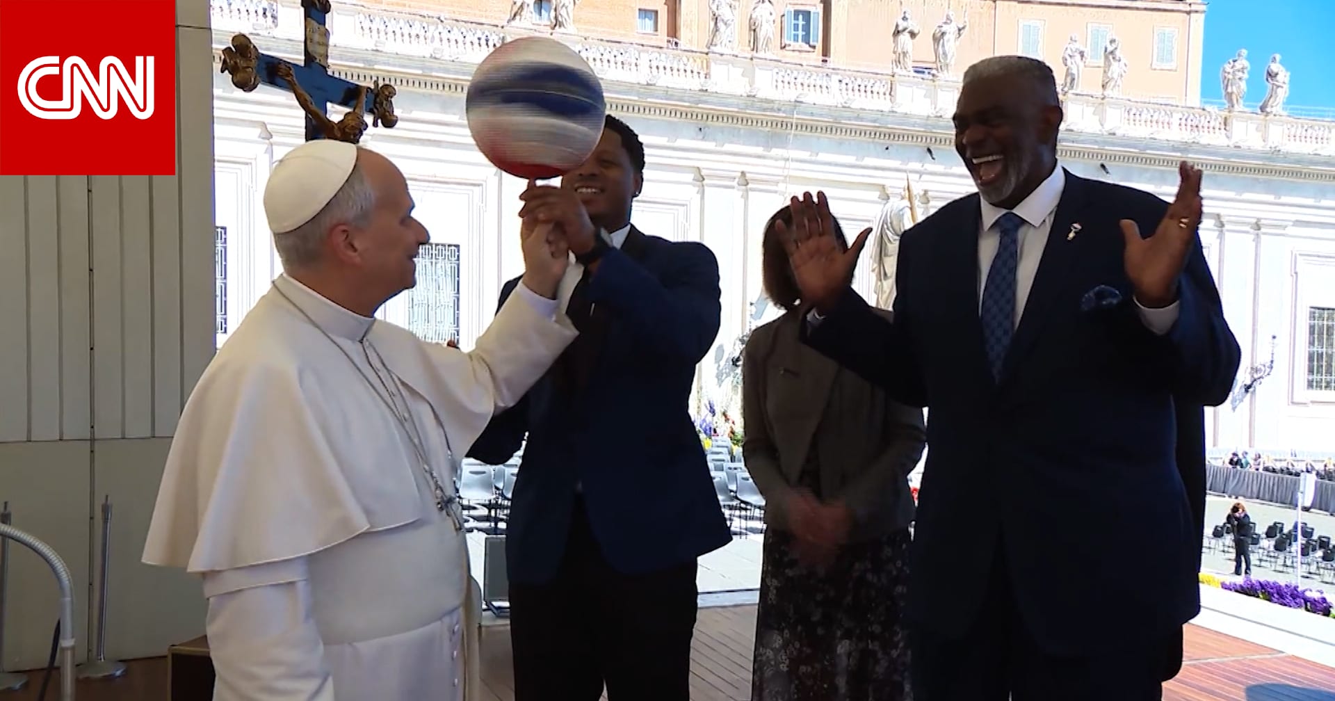 البابا لاوُن يُدير كرة سلة على إصبعه خلال استقبال فريق "هارلم غلوبتروترز" الاستعراضي