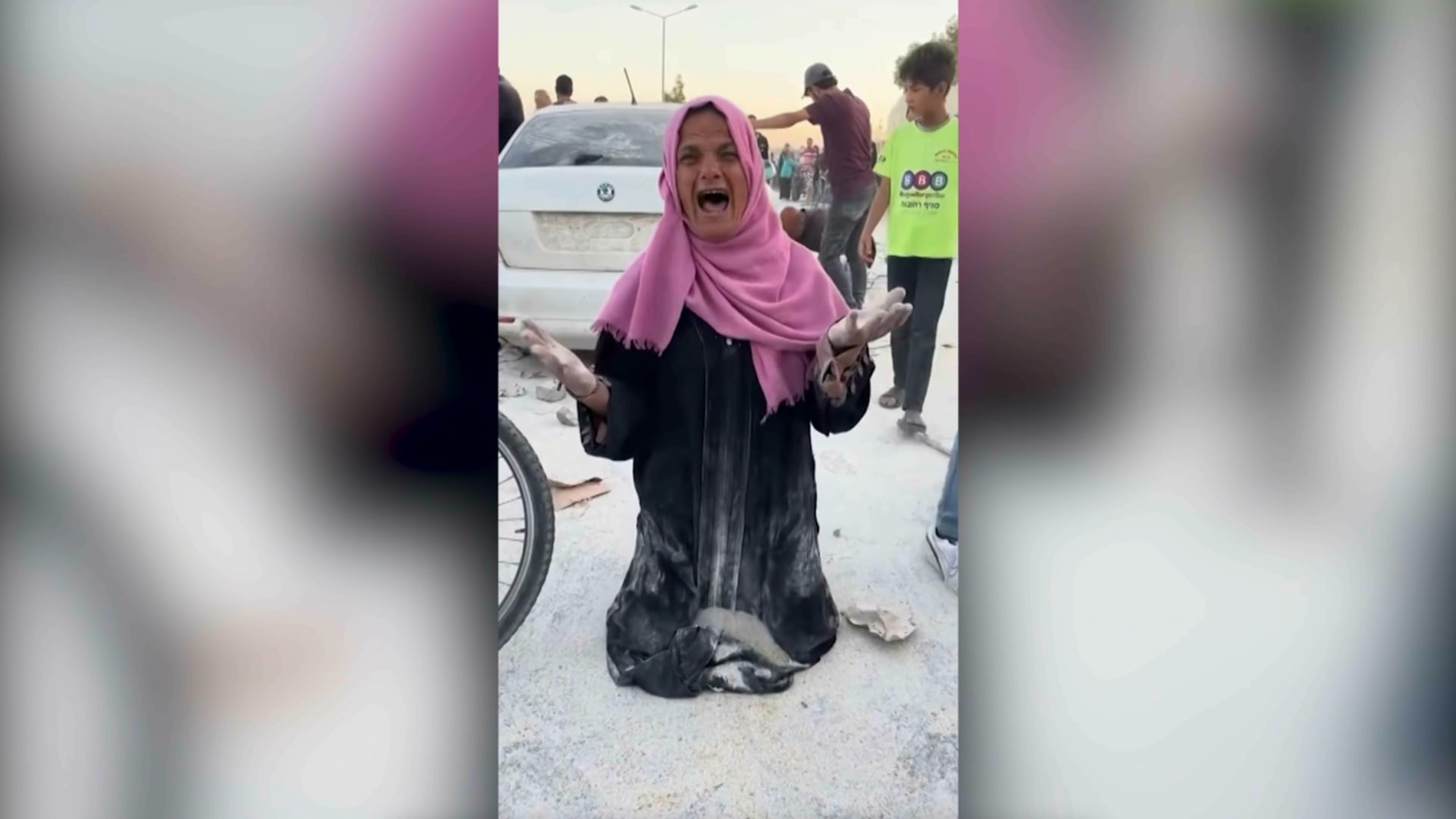 "جوعتونا يا كلاب".. أم فلسطينية تحاول يائسةً جمع بقايا طحين متناثر على الأرض