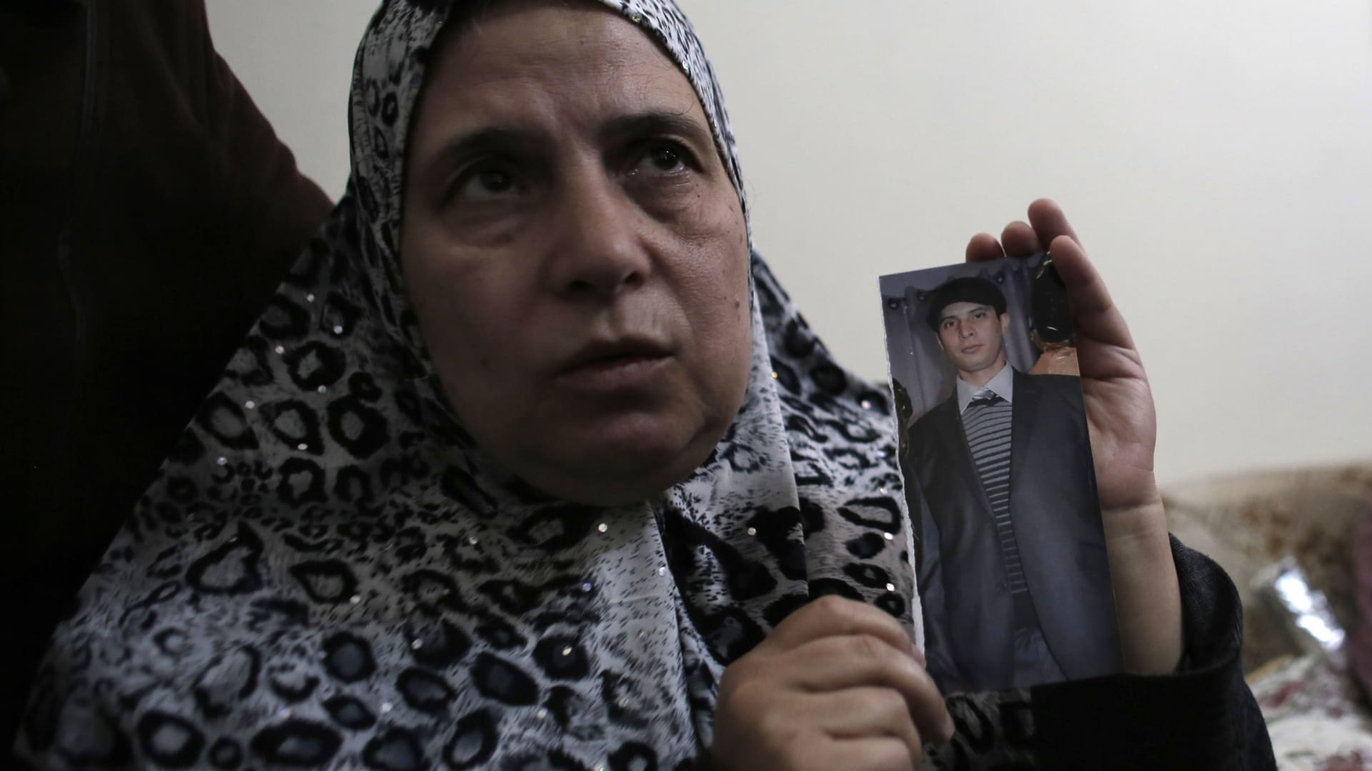 والدة الشاب الفلسطيني معتز حجازي تحمل صورته بعد مقتله صباح الخميس في مواجهات مع الجيش الإسرائيلي بالقدس.