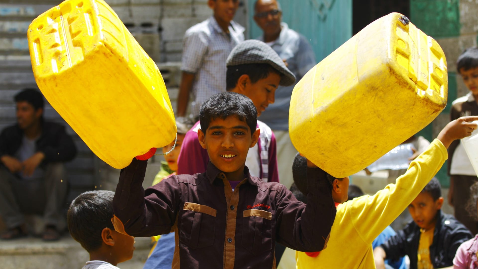صبي يمني بانتظار دوره لنيل حصته من المياه من صنوبر عام في صنعاء