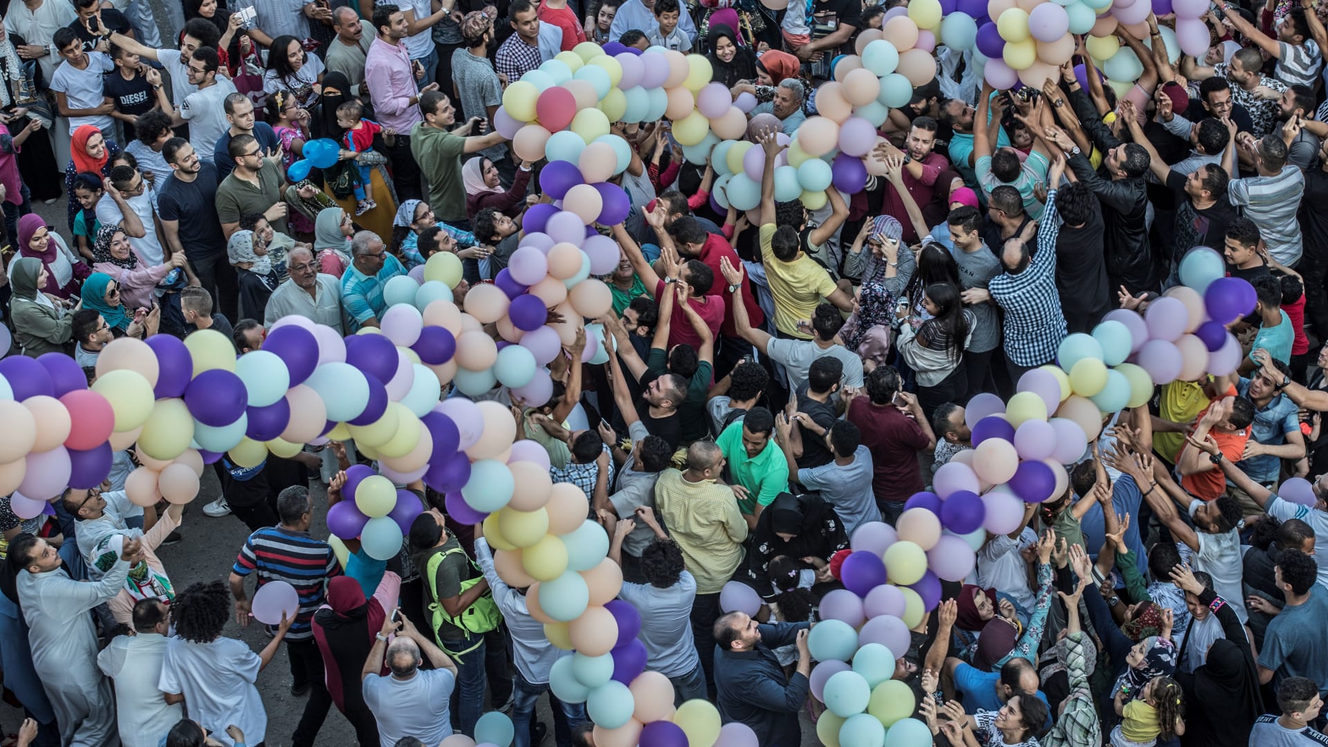 مصريون يلتقطون البالونات بعد أداء صلاة عيد الأضحى أمام مسجد الصديق بالقاهرة.