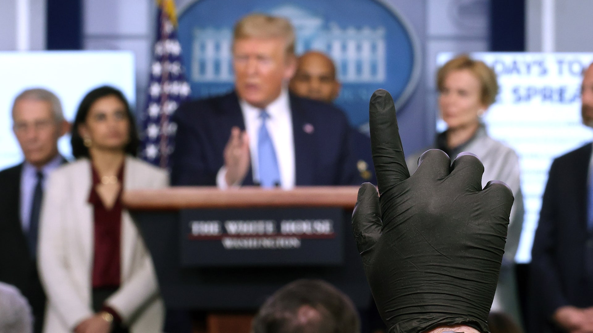 صحفي يرتدي قفازا يرفع يده ليسأل الرئيس الأمريكي دونالد ترامب سؤالاً خلال إيجاز حول فيروس كورونا في البيت الأبيض