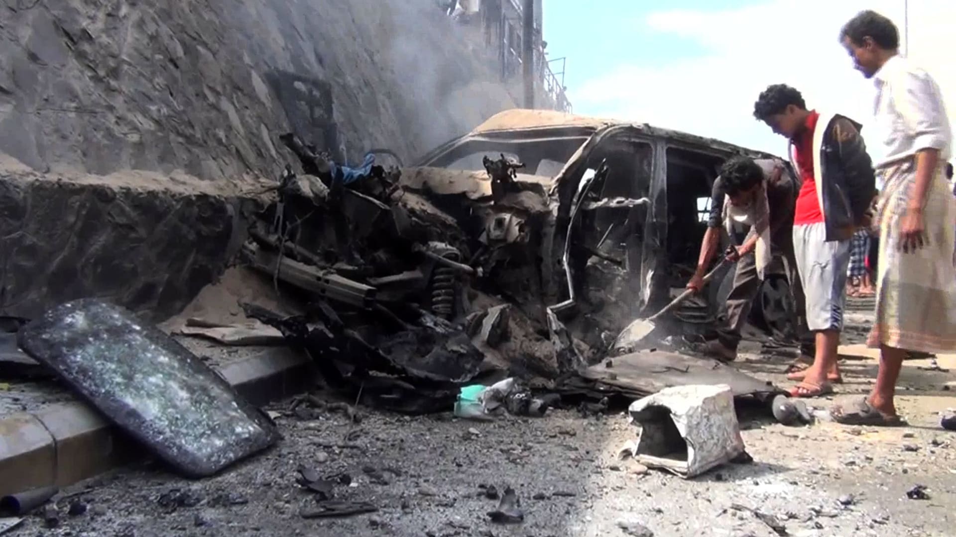 أرشيفية - يمنيون يتفقدون السيارة المحطمة لمحافظ عدن، جعفر سعد، بعد انفجار استهدف موكبه في عدن، مما أسفر عن مقتله هو وبعض حراسه الشخصيين في 6 ديسمبر / كانون الأول 2015