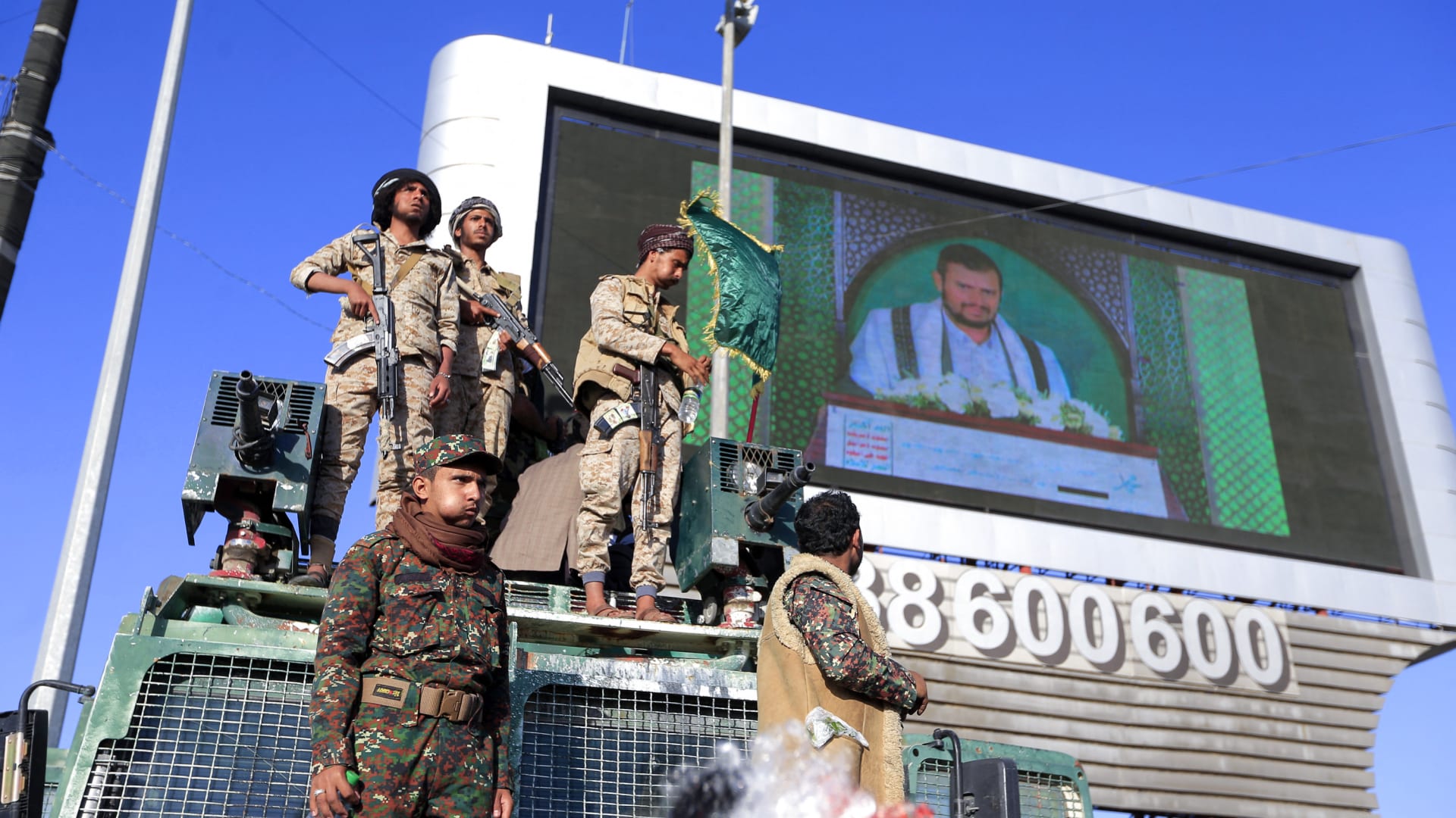 مقاتلون موالون للحوثيين في اليمن يقفون كحرس بينما يخاطب زعيمهم عبد الملك الحوثي حشدًا خلال الاحتفال بذكرى ولادة النبي محمد، في العاصمة اليمنية صنعاء في 18 أكتوبر 2021