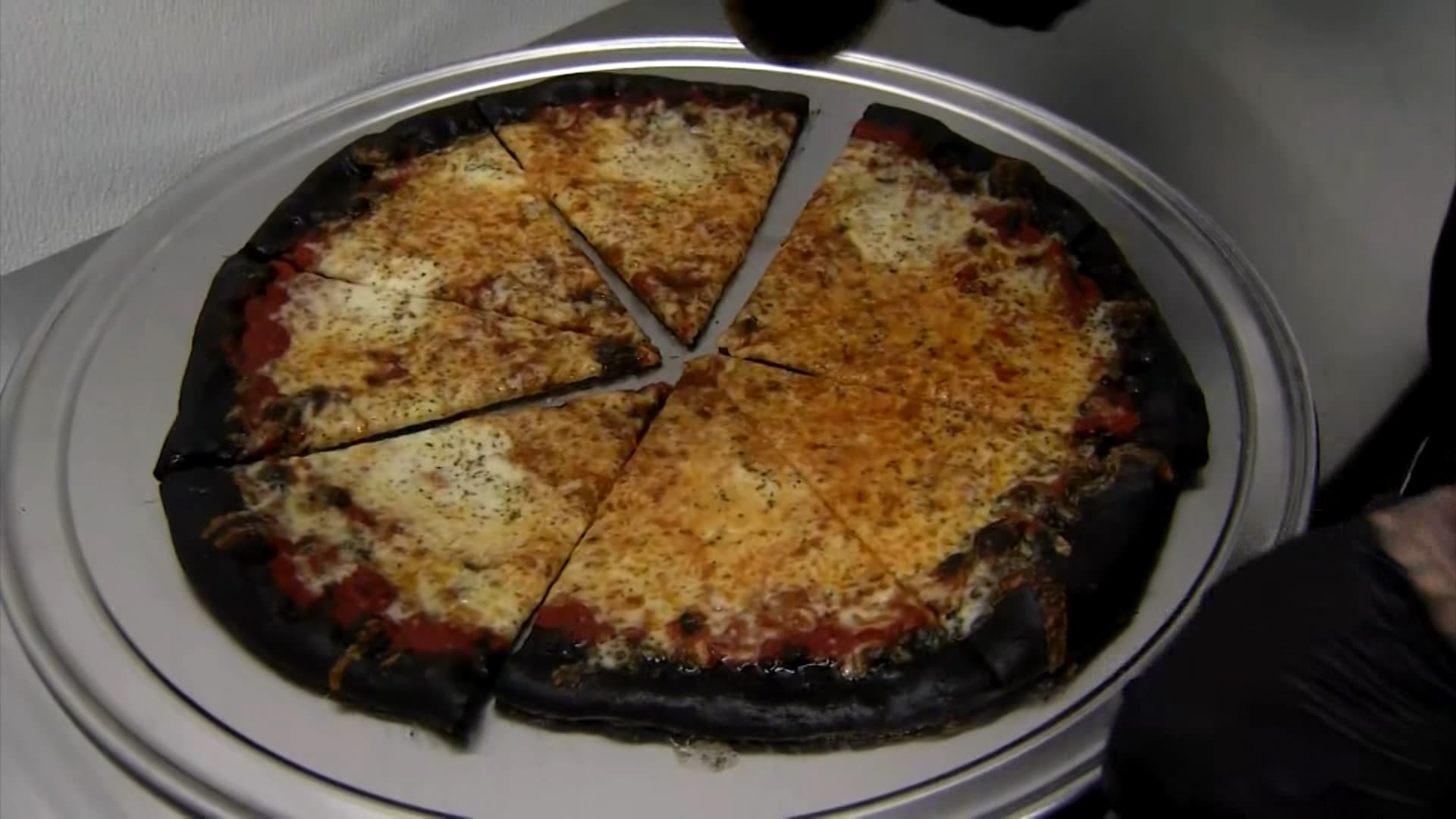 مطعم أمريكي يقدم “بيتزا جريمة القتل” بعجينة سوداء.. كيف هو طعمها؟
