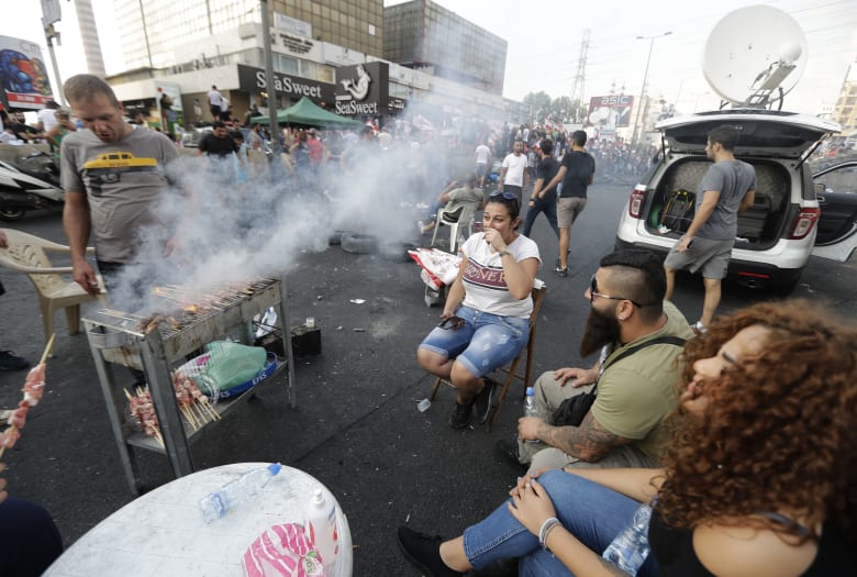 متظاهر لبناني يشوي اللحم على طريق سريع يربط بيروت بشمال لبنان، في زوق مصبح متظاهر لبناني يشوي اللحم على طريق سريع يربط بيروت بشمال لبنان، في زوق مصبح