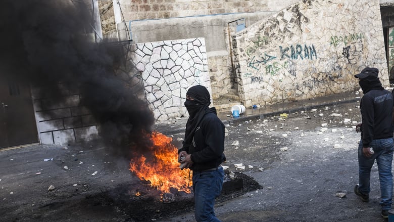 النيران تشتعل في أحد الإطارات قرب شاب فلسطيني بالقدس خلال مواجهات مع القوات الإسرائيلية. النيران تشتعل في أحد الإطارات قرب شاب فلسطيني بالقدس خلال مواجهات مع القوات الإسرائيلية.