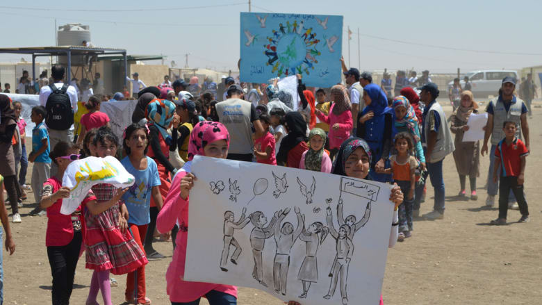 أطفال "الزعتري" يرفضون التخلي عن الأمل بمسيرة للسلام العالمي أطفال "الزعتري" يرفضون التخلي عن الأمل بمسيرة للسلام العالمي