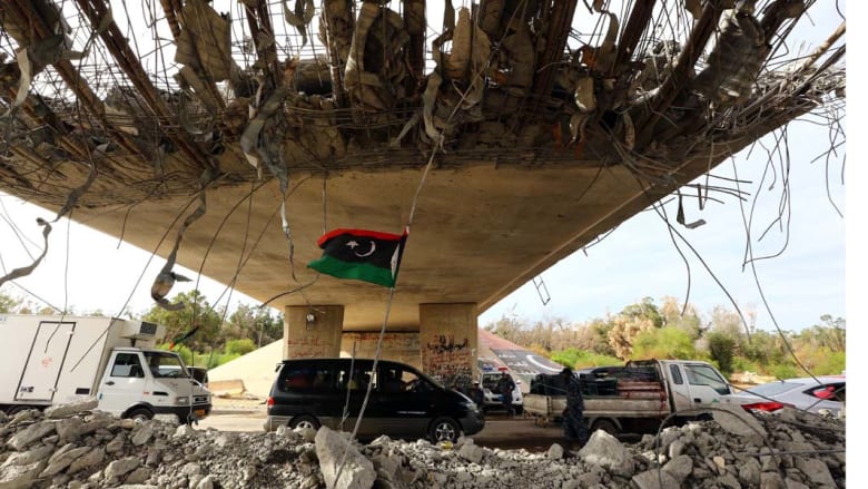 معسكر 27 ، ليبيا-- العلم الليبي يظهر تحت جسر مهدم جزئيا حيث أقامت الشرطة حاجزا على الطريق المؤدي إلى العاصمة طرابلس من جهة الغرب، حيث تتصارع مليشيات مسلحة للسيطرة على العاصمة، 9 سبتمبر 2014 معسكر 27 ، ليبيا-- العلم الليبي يظهر تحت جسر مهدم جزئيا حيث أقامت الشرطة حاجزا على الطريق المؤدي إلى العاصمة طرابلس من جهة الغرب، حيث تتصارع مليشيات مسلحة للسيطرة على العاصمة، 9 سبتمبر 2014