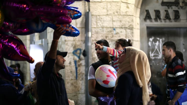 سيدة فلسطينية تنظر إلى مجموعة من البالونات يحملها أحد الباعة في مدينة رام الله بالضفة الغربية استعدادا لعيد الأضحى. سيدة فلسطينية تنظر إلى مجموعة من البالونات يحملها أحد الباعة في مدينة رام الله بالضفة الغربية استعدادا لعيد الأضحى.