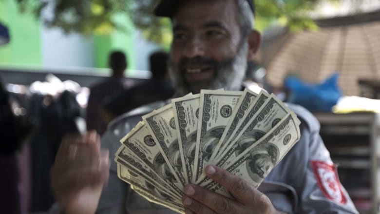 فلسطيني موظف بحكومة حماس السابقة يستعرض دولارات بعد تلقيه جانبا من راتبه المتأخر لعدة أشهر فلسطيني موظف بحكومة حماس السابقة يستعرض دولارات بعد تلقيه جانبا من راتبه المتأخر لعدة أشهر