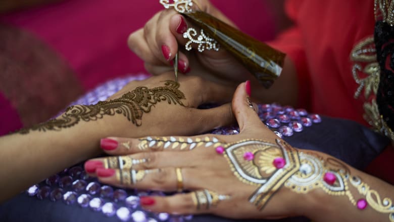 سيدة ترسم على يد أخرى نقوض الحناء صبيحة يوم عيد الأضحى سيدة ترسم على يد أخرى نقوض الحناء صبيحة يوم عيد الأضحى