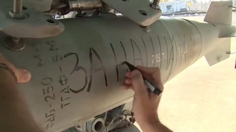 بالفيديو.. طيارون روس يكتبون رسائل لداعش على قنابل قبل استهداف مواقعهم بسوريا