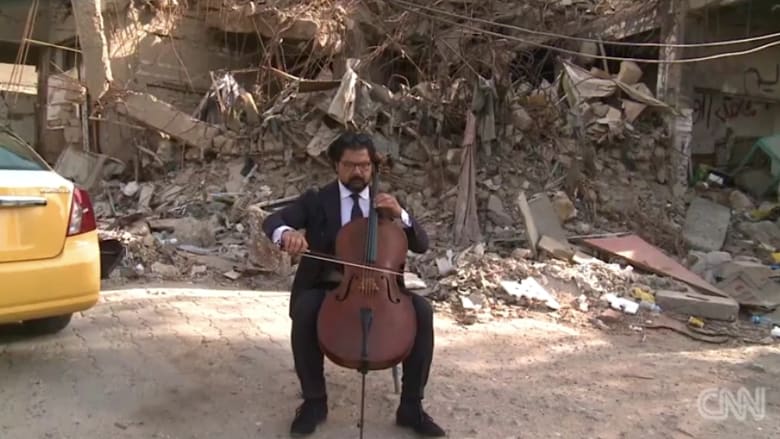 شاهد… شاب يحارب الإرهاب بعزف التشيللو في شوارع بغداد