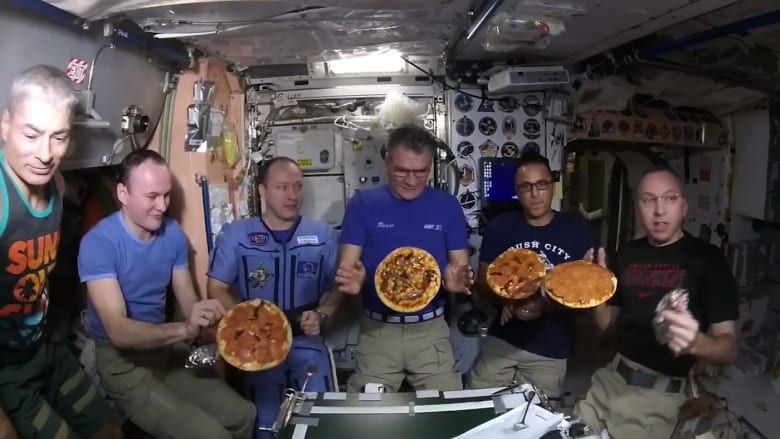 رواد فضاء يستمتعون بالبيتزا مع انعدام الجاذبية