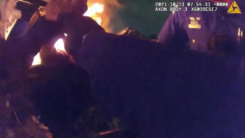 شاهد لحظات الخوف خلال إنقاذ ضابطي شرطة لرجل فاقد الوعي بسيارة تلتهمها النيران