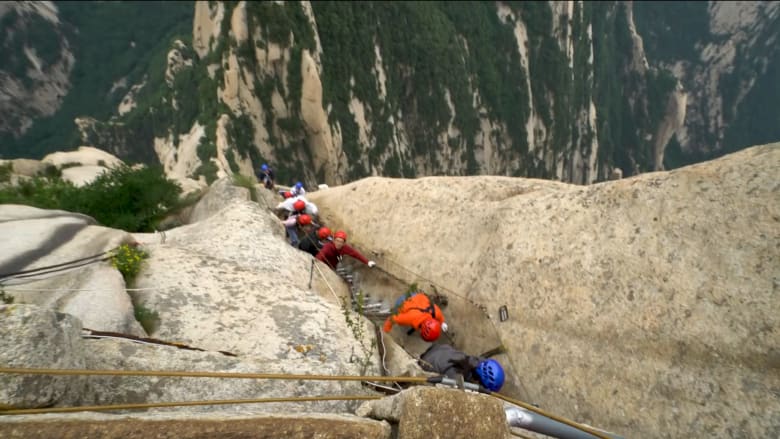 رجل يخوض تجربة خيالية على جبل معروف بانحداره في الصين