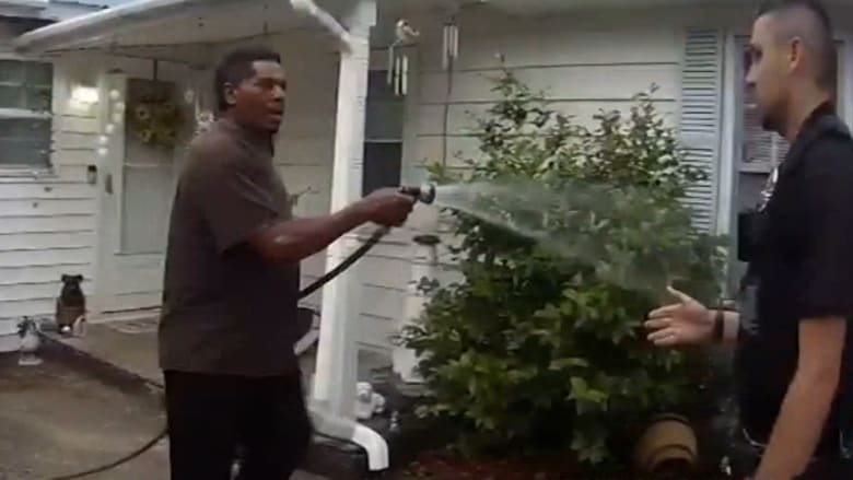 ضباط أمريكيون يعتقلون قسًا من ذوي البشرة السوداء بينما كان يسقي زهور جاره.. شاهد المواجهة