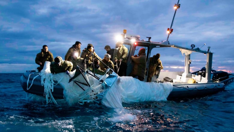 صور تُظهر استعادة البحرية الأمريكية المنطاد الصيني من الماء.. شاهد كيف أخرجوه