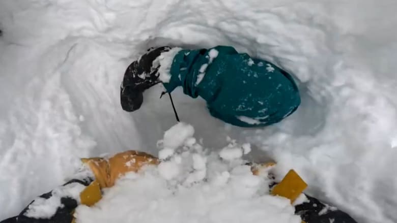 دفن رأسًا على عقب.. شاهد ما حدث لمتزلج علق في حفرة وسط الثلوج