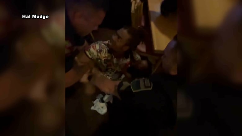 فيديو يُظهر ضابط شرطة يلكم رجلًا يجلس وطفله الرضيع بين ذراعيه