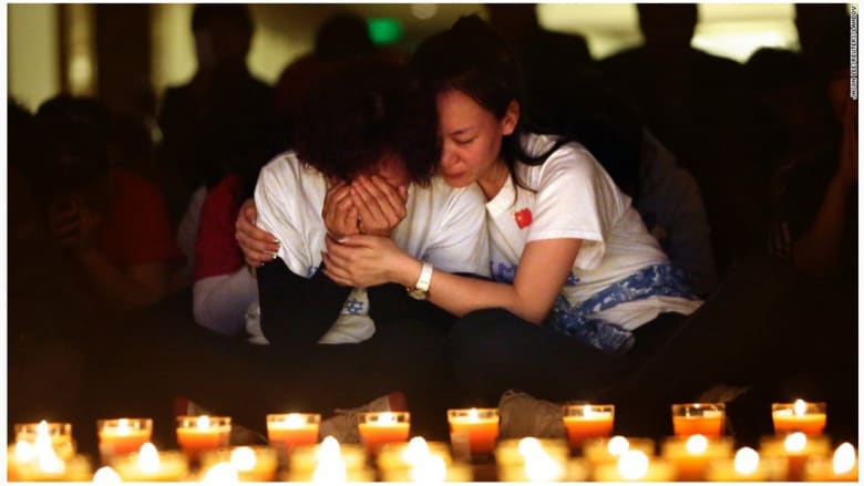 امرأة تبكي في بكين، خلال مسيرة بالشموع لضحايا الطائرة الماليزية الرحلة 370.