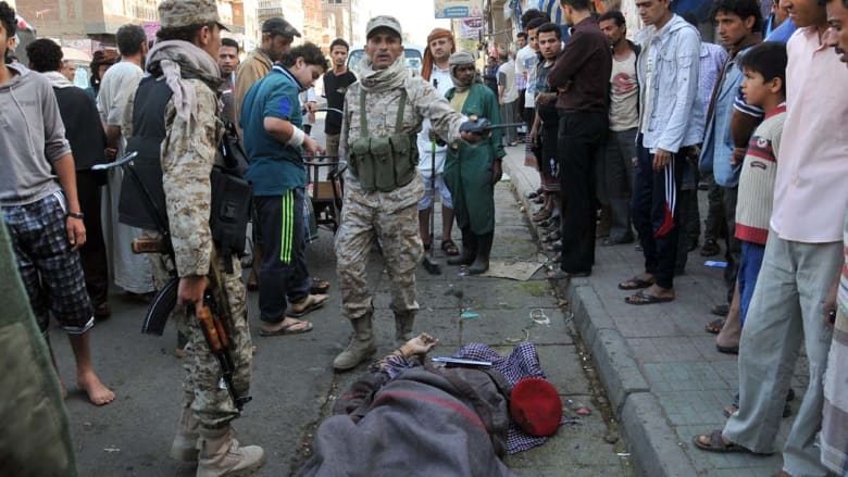 جنود ومواطنون يتجمعون حول جثة قائد عسكري يمني قتل اثناء سيره بالشارع في العاصمة صنعاء الاثنين 5 مايو/ أيار 2014.