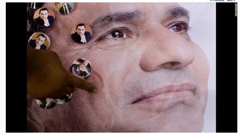 رجل يعلق ملصقاً لمرشح الرئاسة المصرية، عبد الفتاح السيسي.