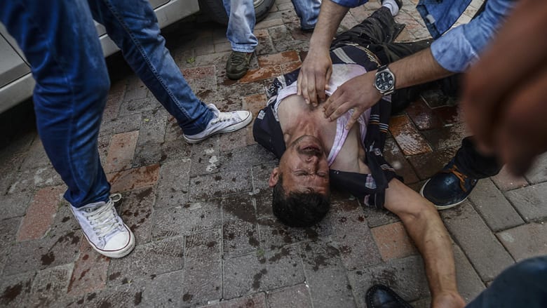 مجموعة من الأشخاص يسعفون شابا أصيب برصاصة في مواجهات مع قوات الشرطة التركية