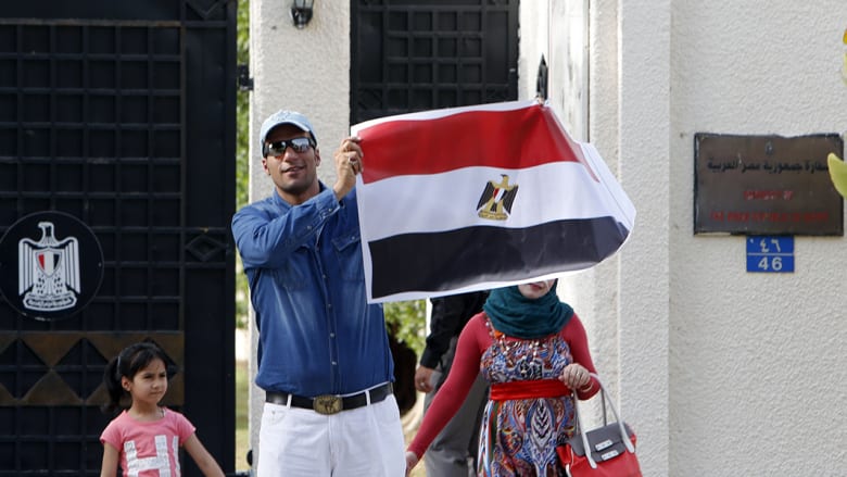 مصري يحمل علم بلاده خلال عمليات التصويت في سلطنة عمان.