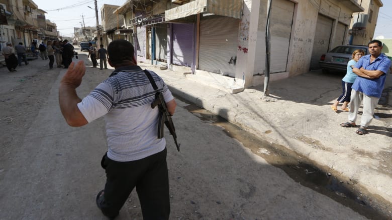 مسلح في أحد شوارع بلدة برطلة إلى الشرق من الموصل حيث ما زال هناك وجود لبعض عناصر الشرطة بحراسة الكنائس 