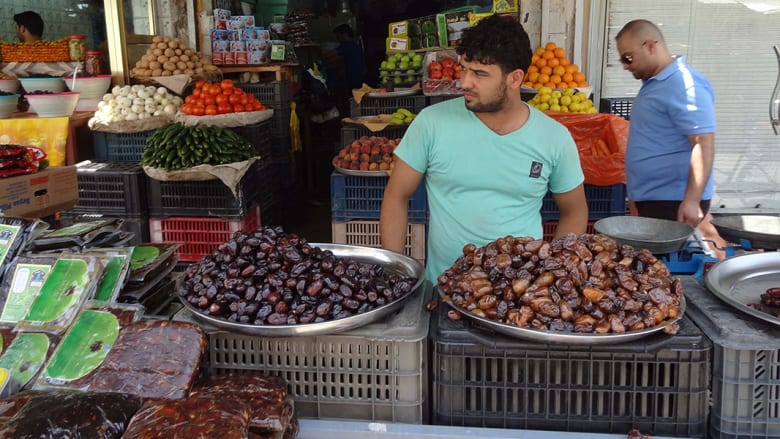 بائع عراقي يقف في محله بسوق في الكركوك.