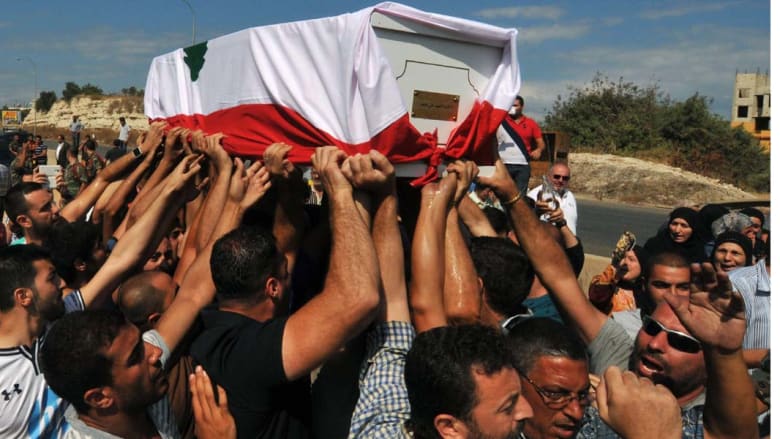 القملون، لبنان -- لبنانيون من الطائفة السنية يشعيون جثمان الجندي علي سيد ملفوفة بالعلم اللبناني في قرية القلمون إلى الجنوب من طرابلس الذي أعلن "الجهاديون" عن قطع رأسه عرسال - 3 سبتبمبر/ أيلول 2014