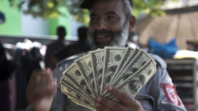 فلسطيني موظف بحكومة حماس السابقة يستعرض دولارات بعد تلقيه جانبا من راتبه المتأخر لعدة أشهر 