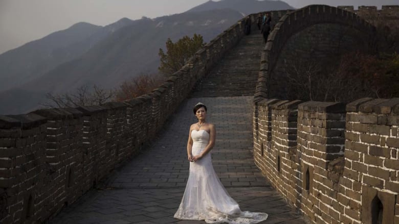عروس صينية بانتظار التقاط صورة الزفاف في جانب من سور الصين العظيم