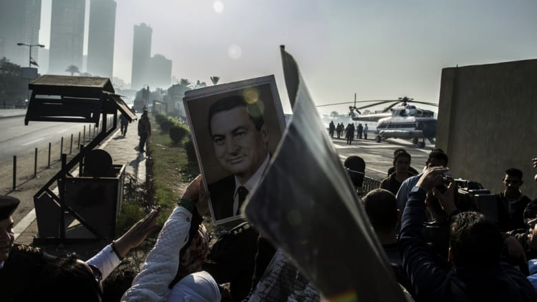 أنصار مبارك يرفعون صوره فيما تستعد مروحية طبية لنقل الرئيس المصري الأسبق من مستشفى المعادي العسكري إلى قاعة المحكمة