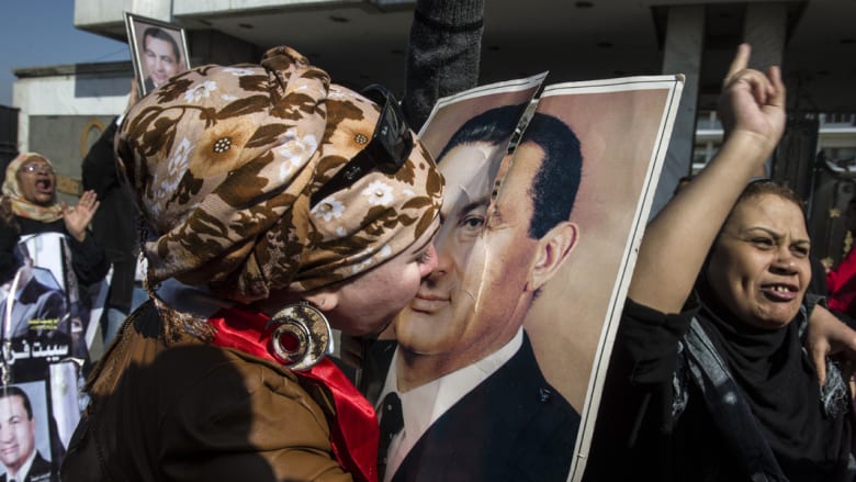  مصرية من أنصار مبارك تقبل صورة له بعد إعلان قرار البراءة