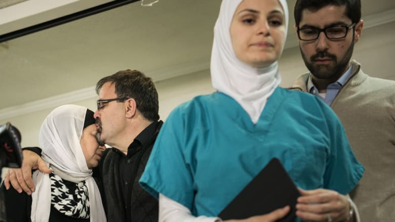 والد ضحية اطلاق النار شادي بركات، يقبل زوجته وتظهر ابنتهما سوزان وهي تغادر بعد مؤتمر صحفي