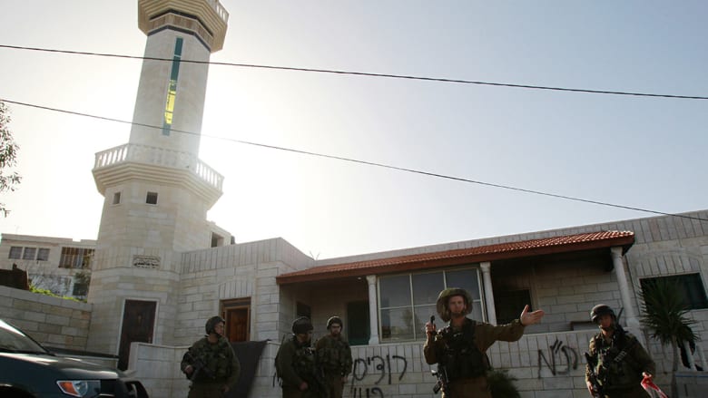 جنود إسرائيليون يطوقون المسجد الذي أحرق قرب بيت لحم.