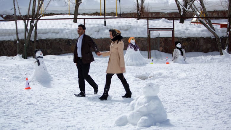 زوجان يمشيان بين مجموعة من التشكيلات الثلجية