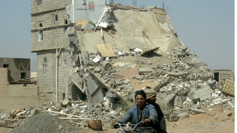 يمني يقود دراجته قرب مبنى مدمر في صعده بعد الهدنة مع الحوثيين 21 فبراير/ شباط 2010