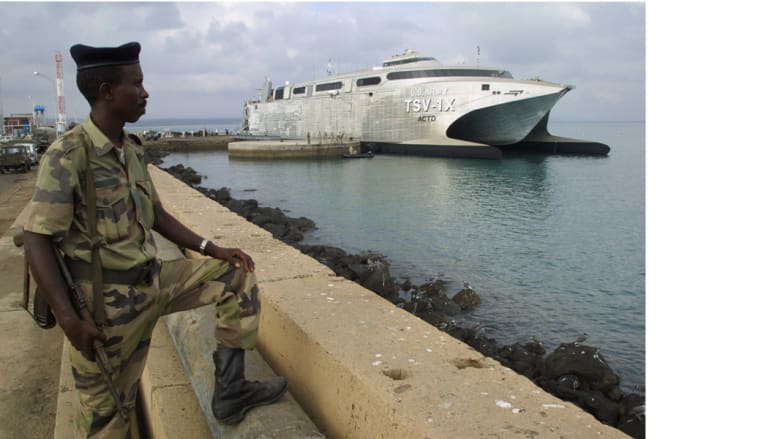 جندي جيبوتي ينظر إلى سفينة نقل أمريكية لقوات التدخل السريع في ميناء جيبوتي حيث يوجد للولايات المتحدة نحو 900 عسكري في معسكر ليمونير، 22 فبراير/ شباط 2003 